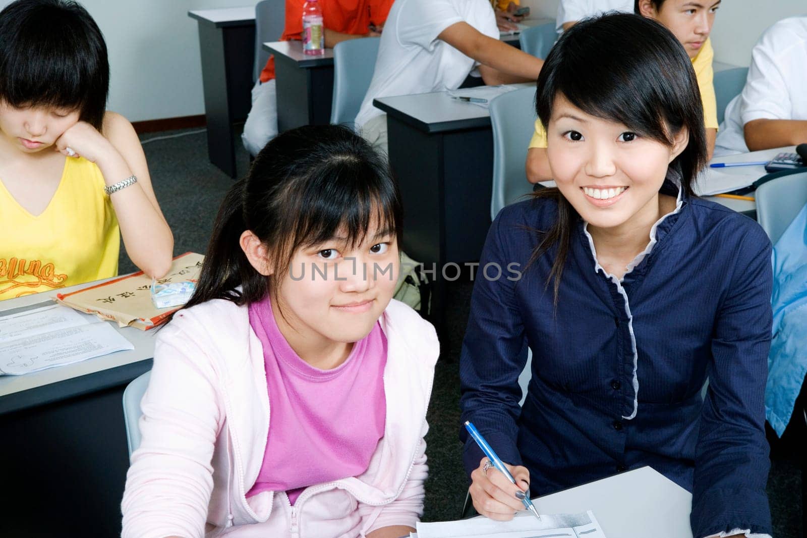 Portrait of a girl filling out a form with her teacherŽs help