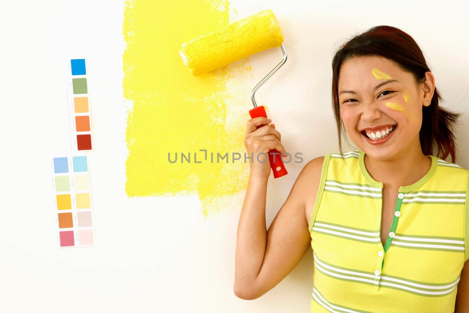 Portrait of a young woman holding a paint roller