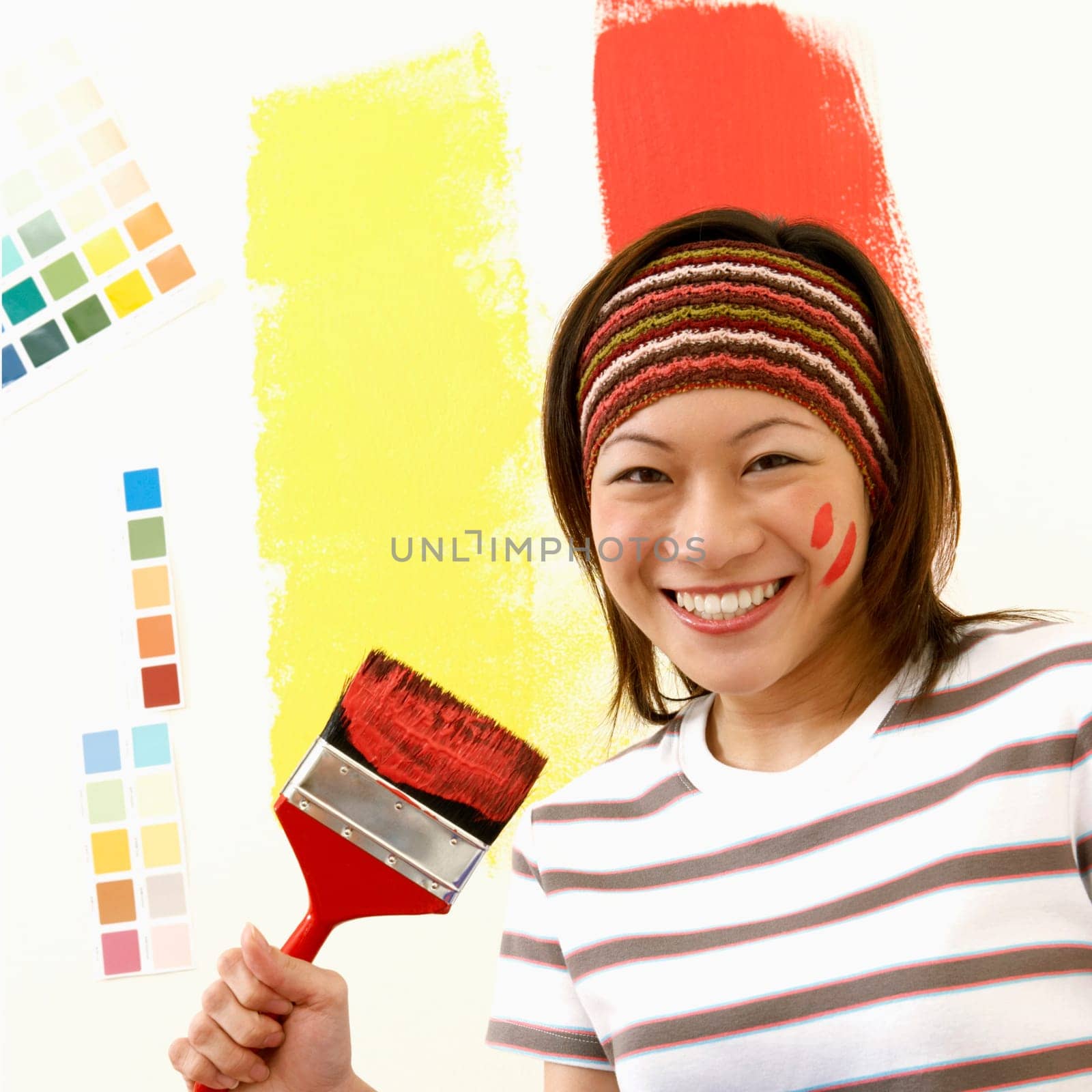 Portrait of a young woman holding a paint tray with a paintbrush