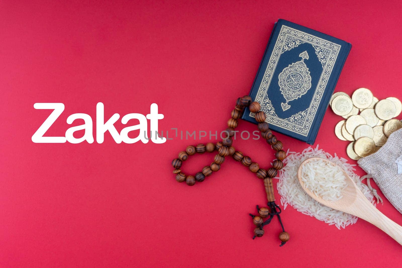 ZAKAT words with Holy Quran, Coins, Rosary and Rice. Zakat concept. Zakat is a form of alm-giving as a religious obligation