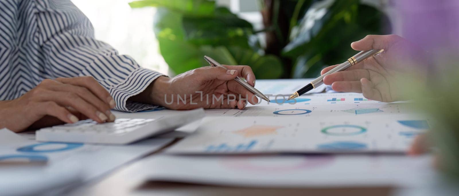 Finance experts collaborate on financial data and calculations, emphasizing teamwork and analytical skills in a bright office setting.