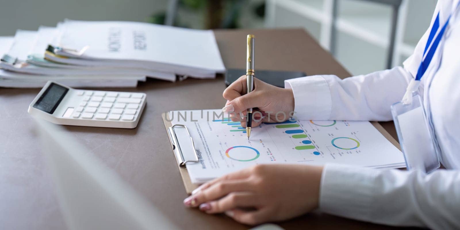 A professional accountant documents financial data and trends, utilizing charts and reports for strategic financial planning.