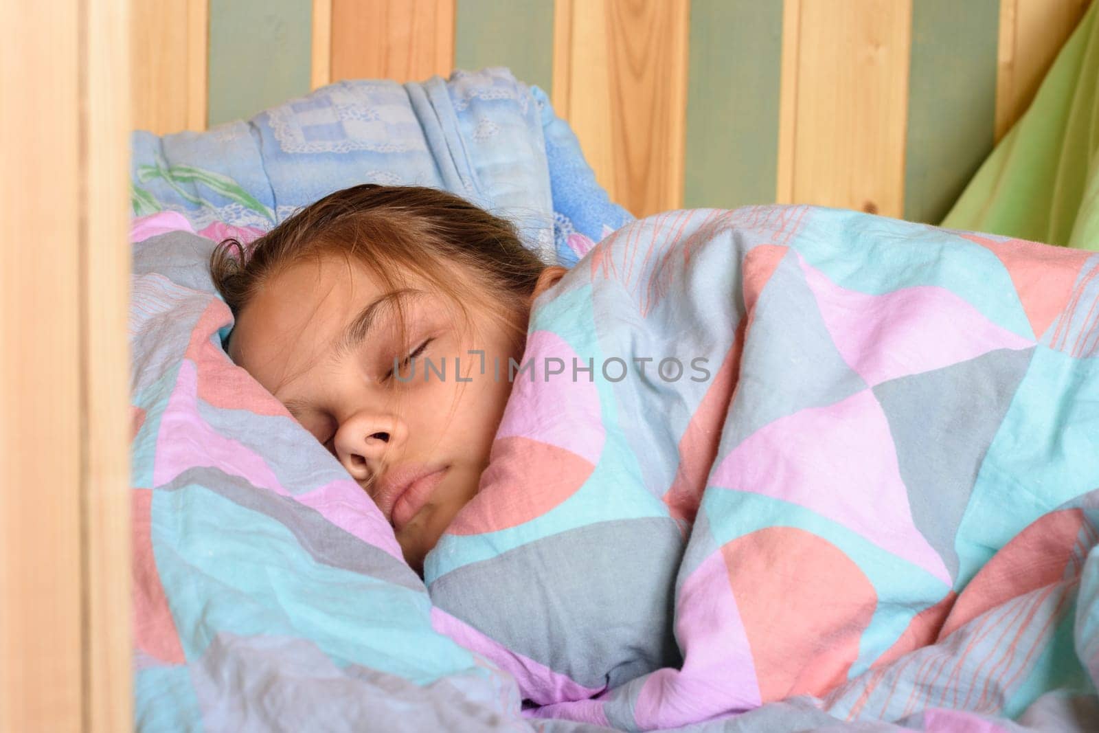 Teenage girl covered with a blanket sweetly sleeping in the early morning