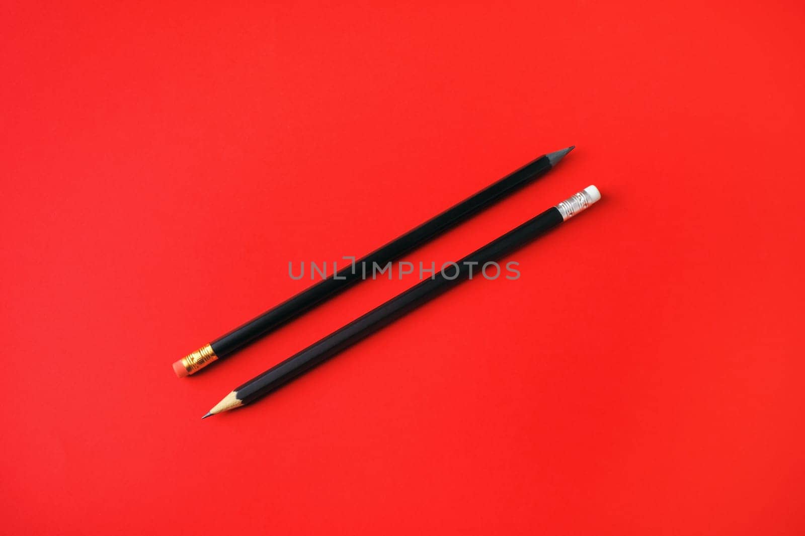 Black pencils with copy space on red paper background. Space for text.