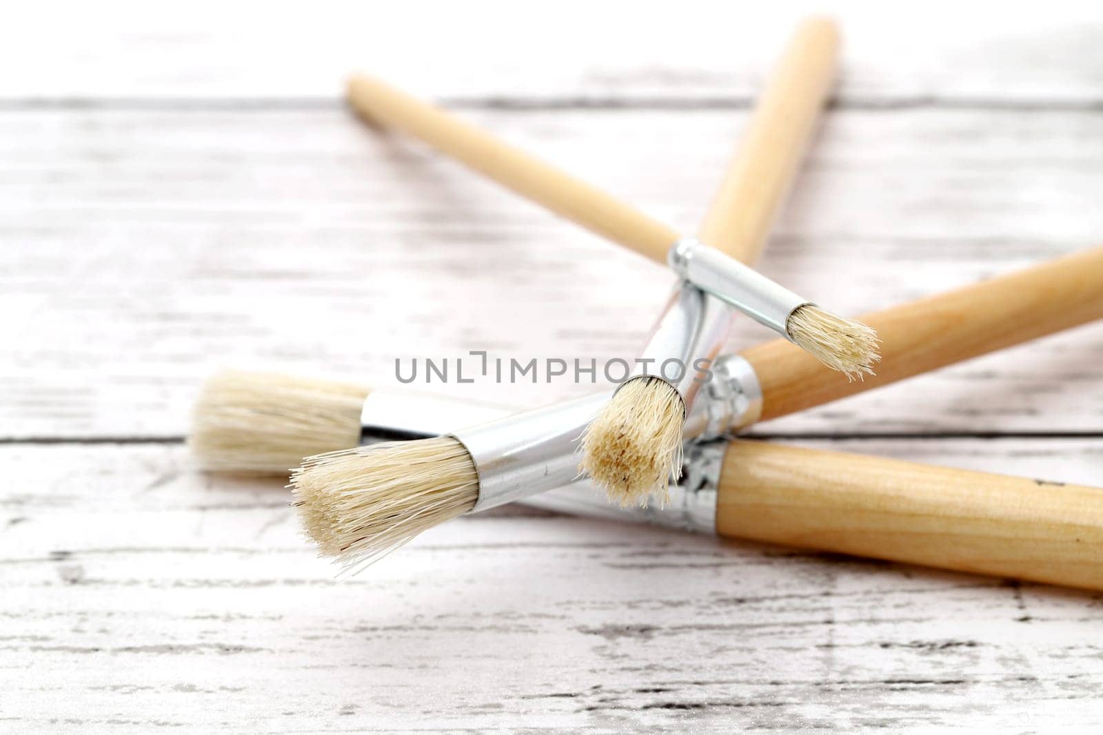 Paint brushes on white grunge wooden table