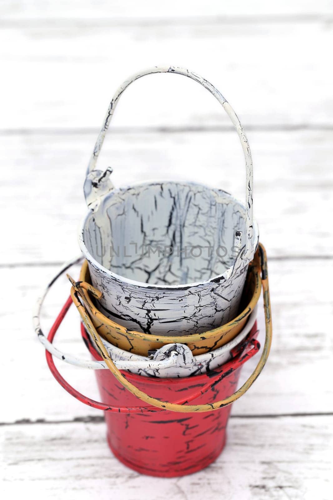 Empty miniature metal bucket on white wooden table