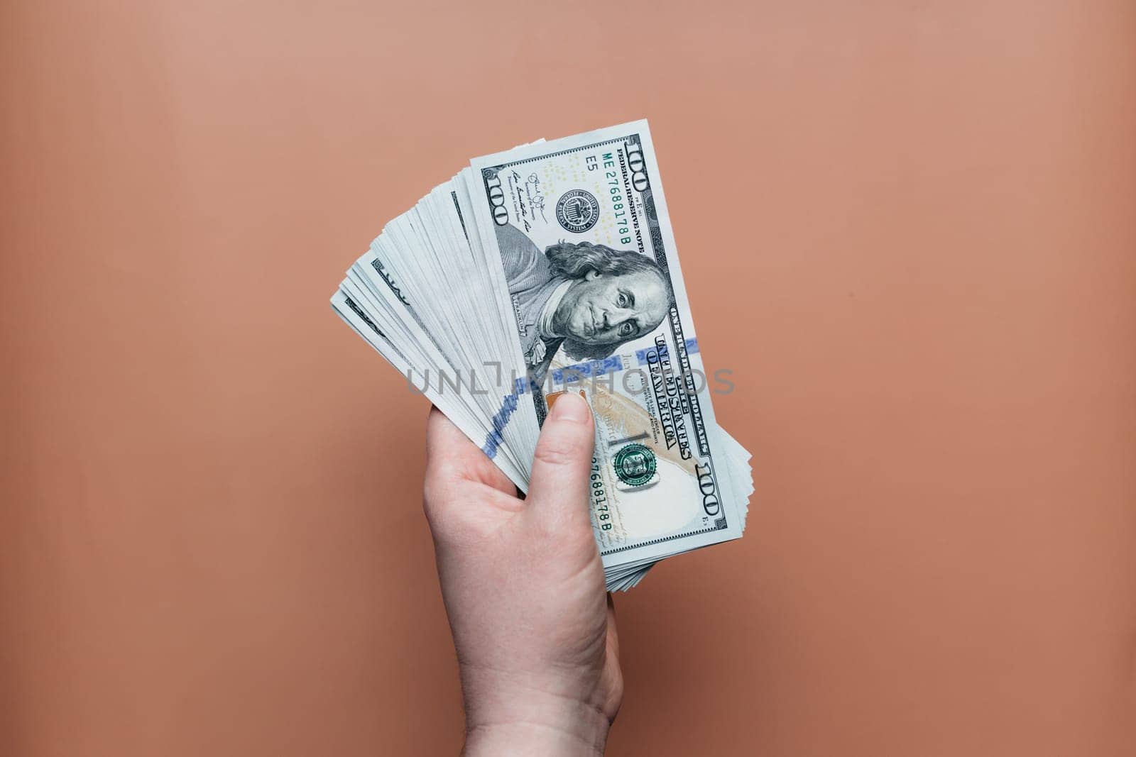 Bundle of dollars in hand on beige background. High quality photo