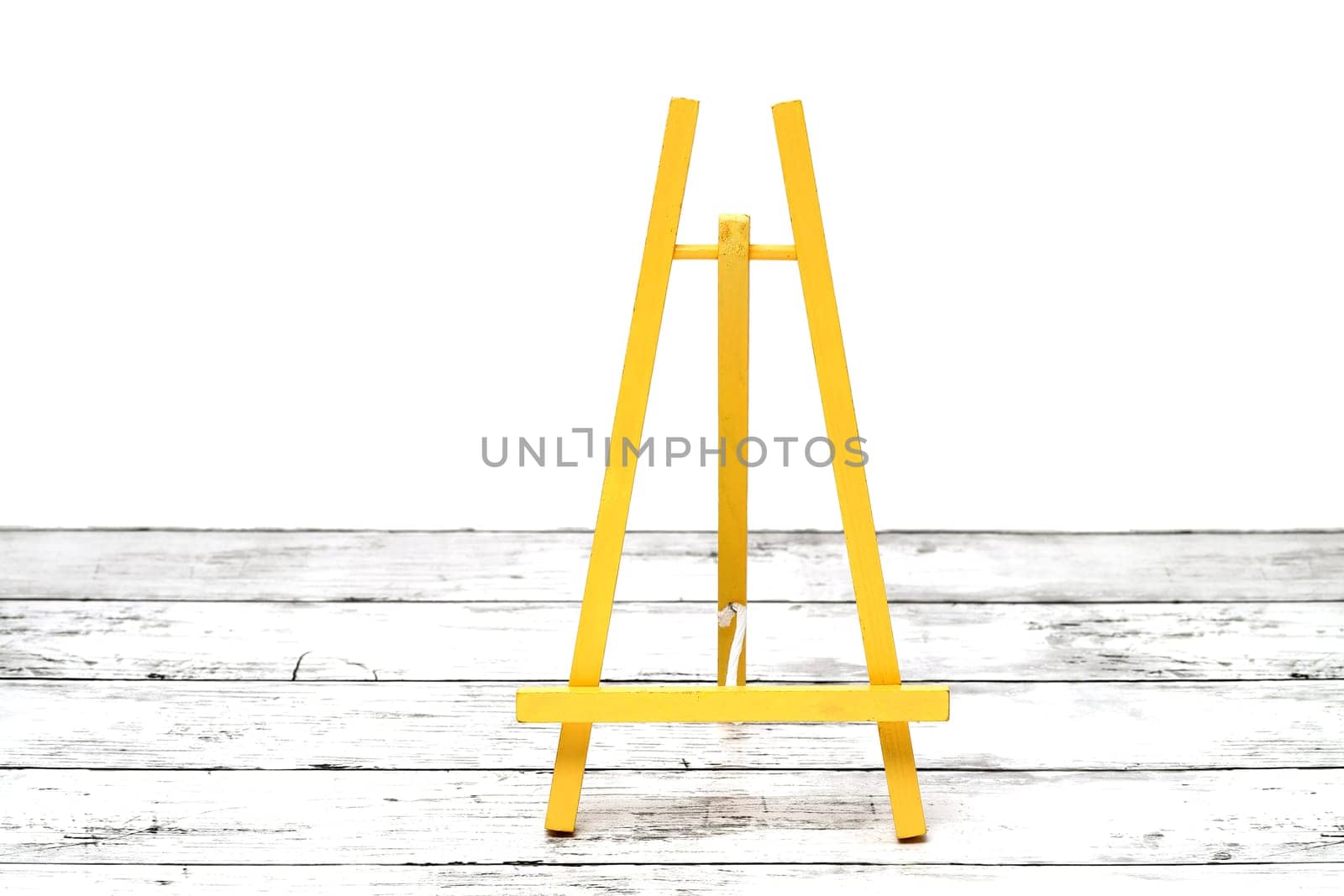 Wooden small easel on a white grunge wooden table