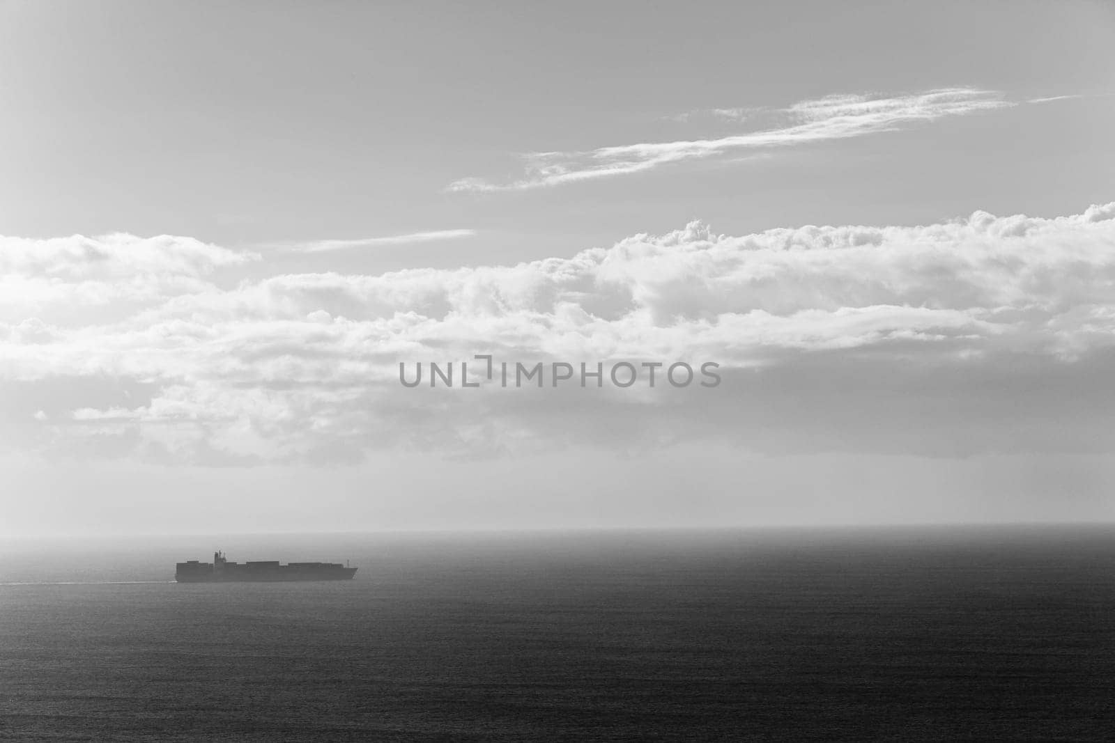 Ship travels open ocean seas overlooking birds-eye in black white vintage contrasts