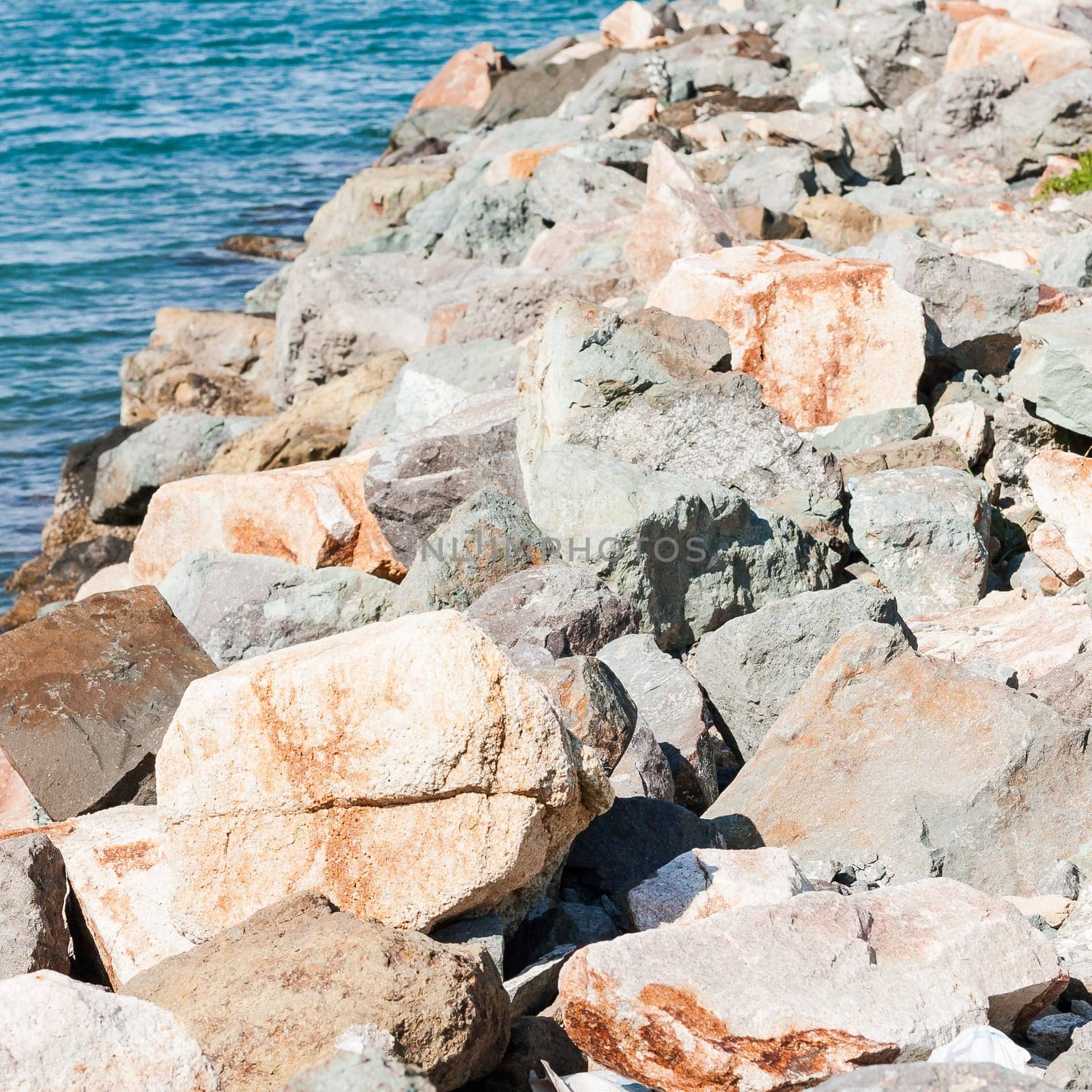 Colored stones on the sea in channel port in Cagliari