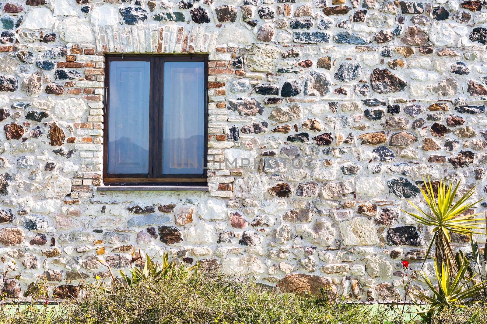 stone wall with window. particular of a stone house.