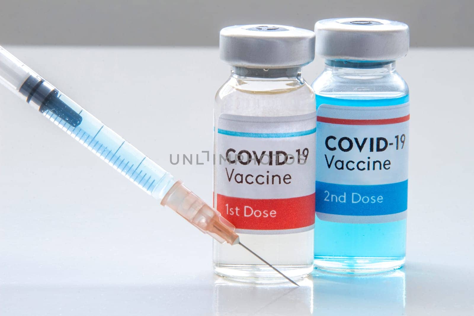 Calgary, Alberta, Canada. Nov. 27, 2020. A Moderna 1st dosis and a 2nd dosis of covid-19 vaccine on a vial bottle and injection Syringe on a white table