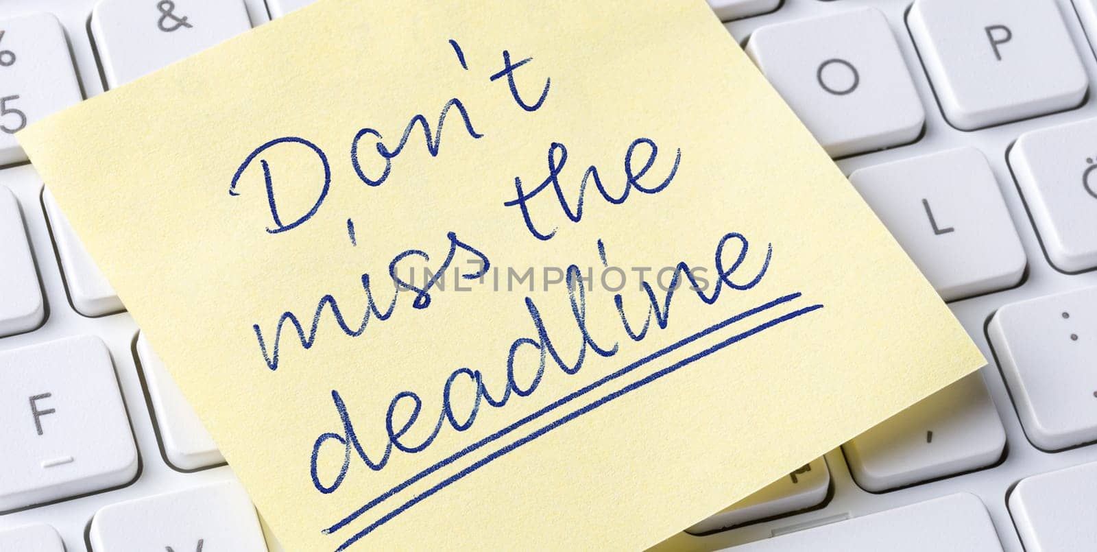 Sticky note on a keyboard - Dont miss the deadline