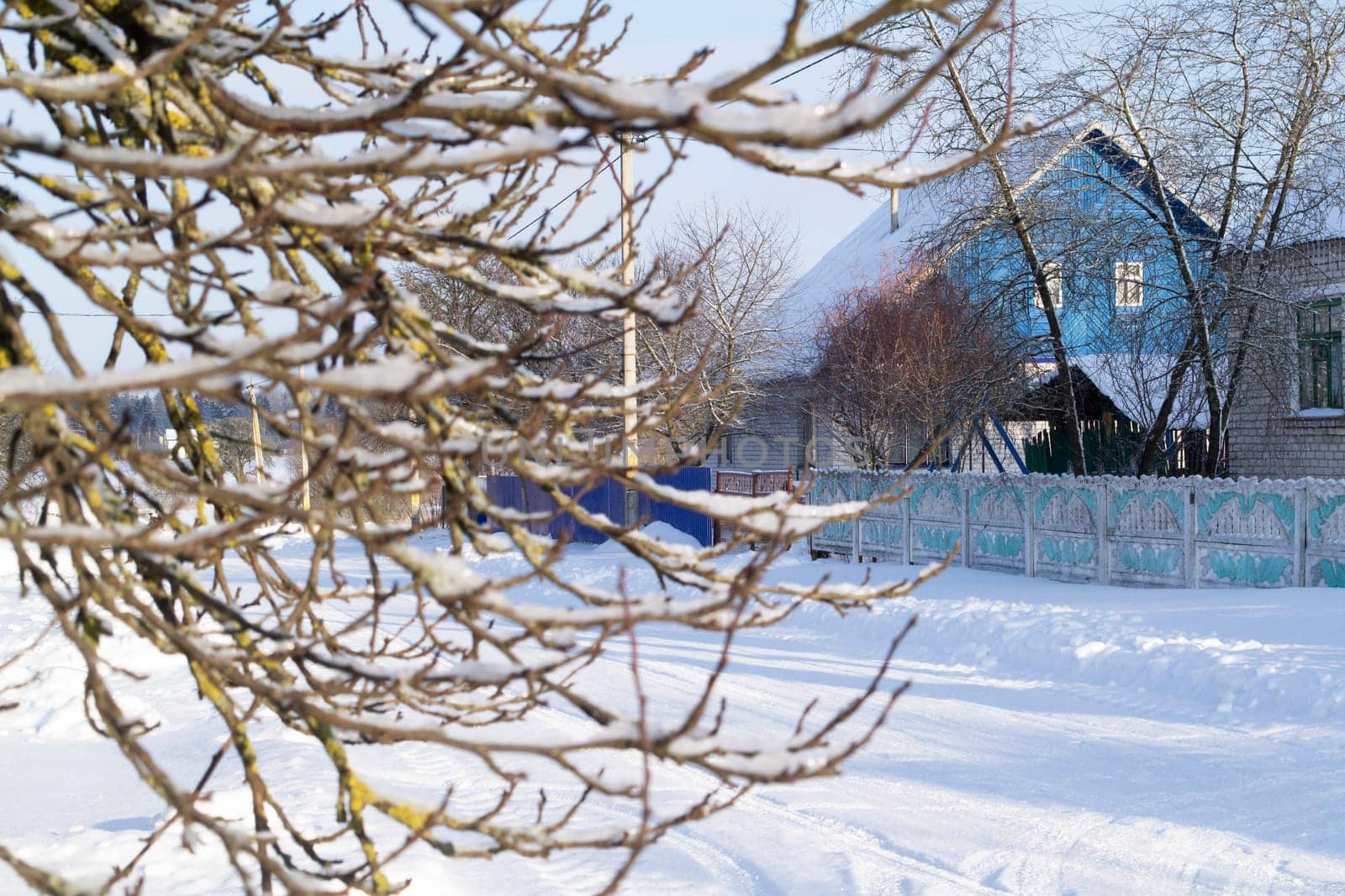 Snowy hills in russian or belarussian countryside in morning, wooden house