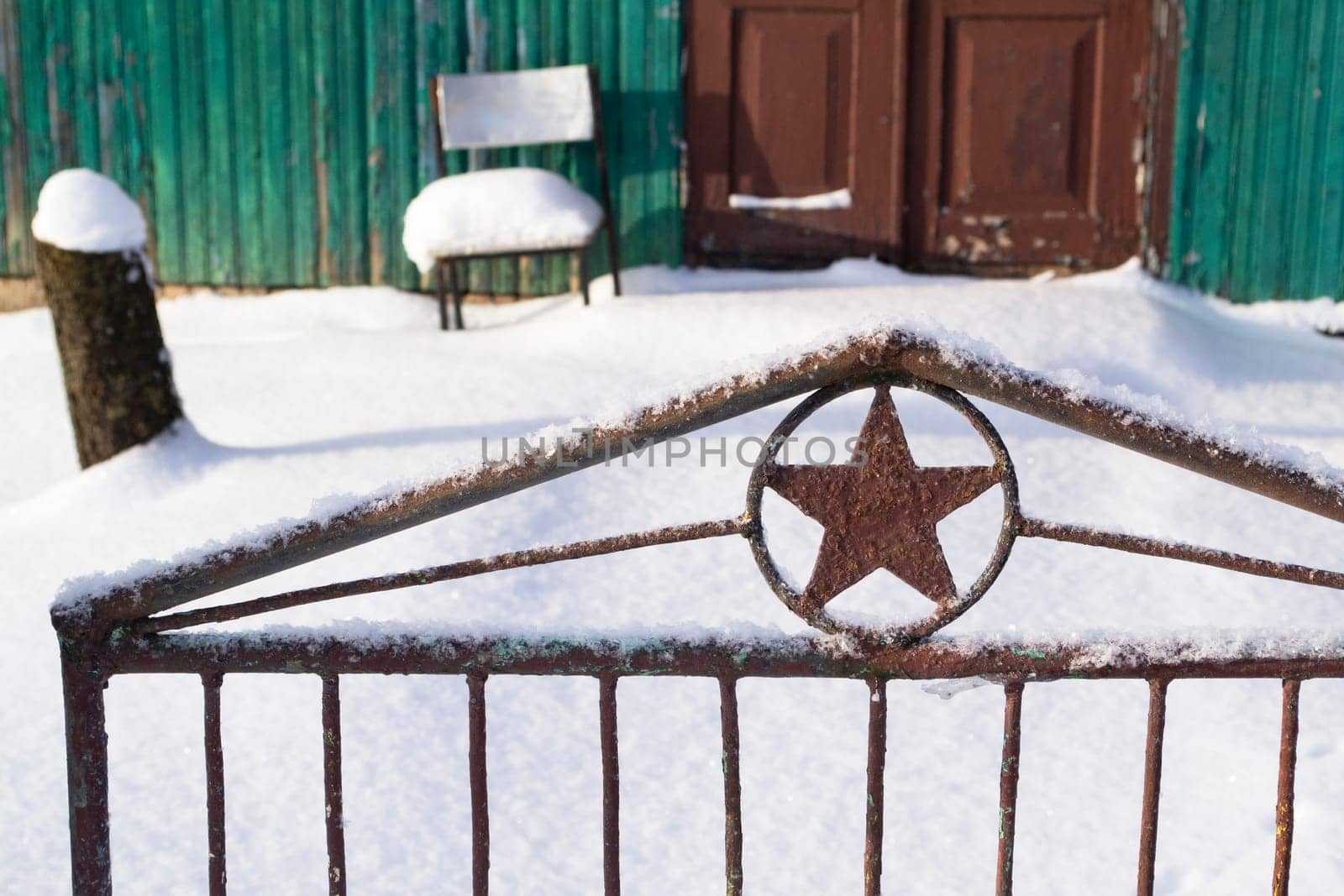 Soviet five finger star on a fence door background an old wooden fence, winter time