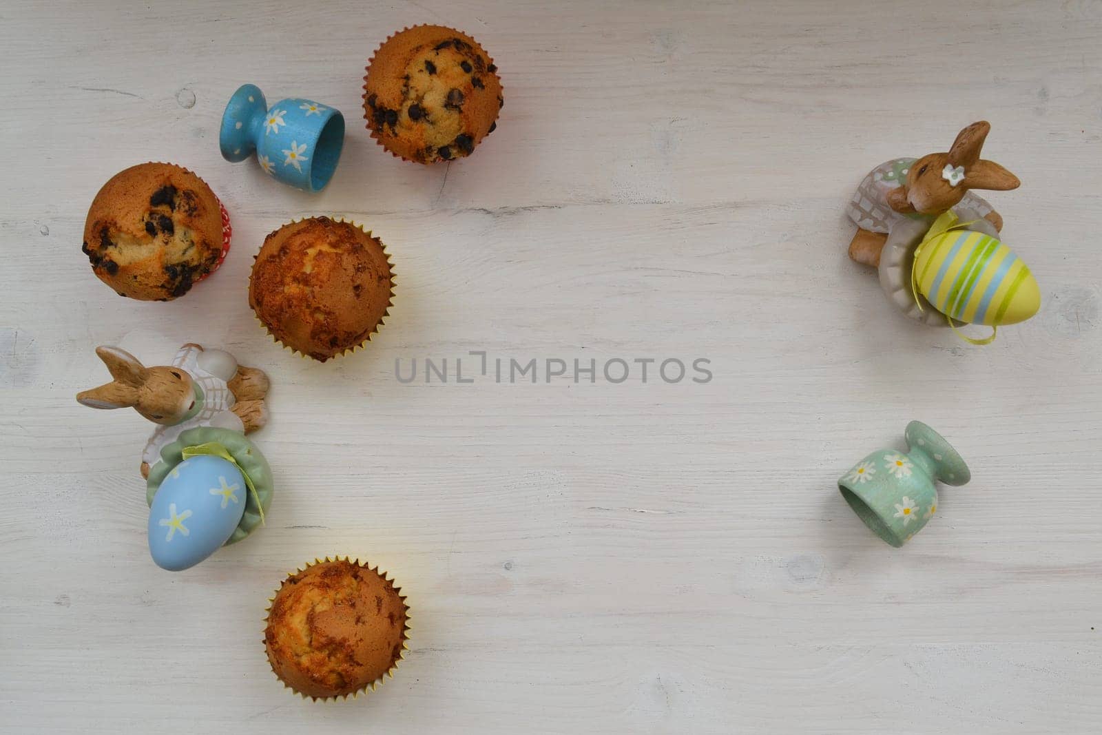 Easter eggs and sweet muffins top view, copy space