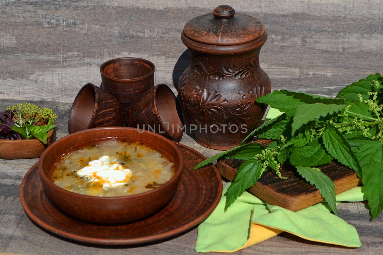 Soup of sorrel and nettles on the rustic table, springtime