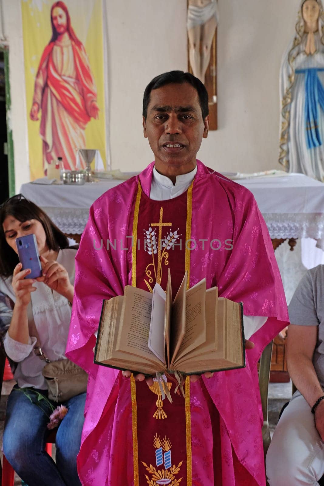 The priest holds the missal, Catholic church in Chunakhali, West Bengal, India