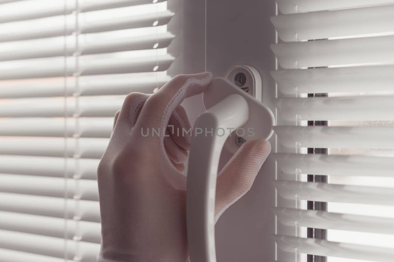 Close-up of hands in gloves with screwdriver, installing a new handle.