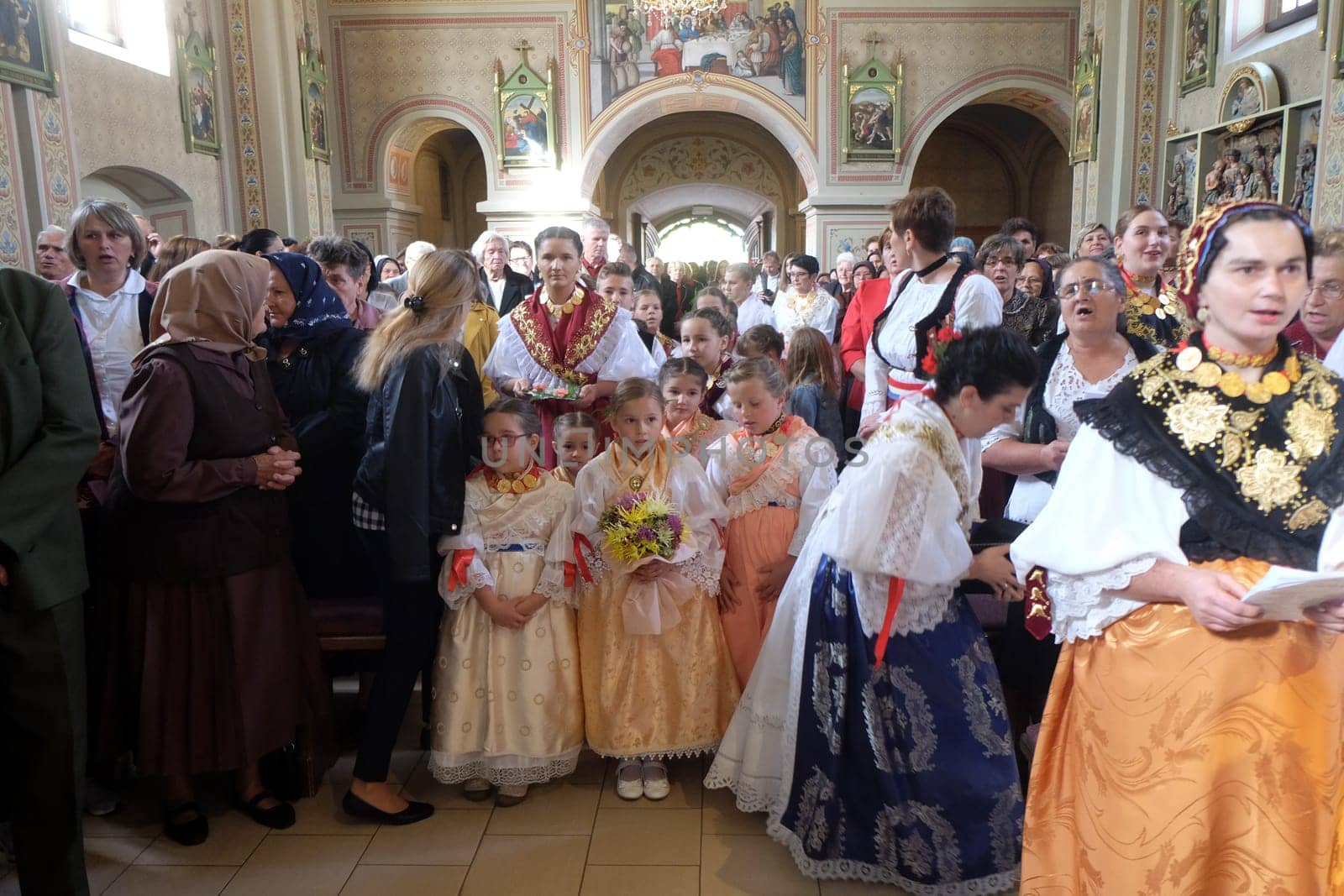 People dressed in traditional regional folk costumes in the church at the Mass on Thanksgiving day in Stitar, Croatia