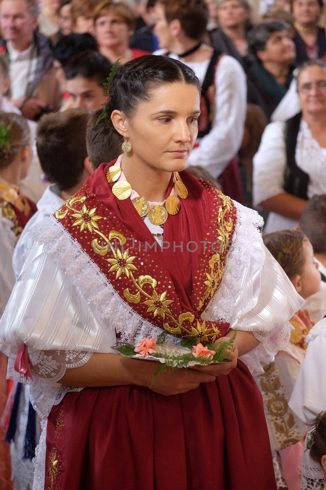 Woman dressed in traditional regional folk costumes in the church at the Mass on Thanksgiving day in Stitar, Croatia