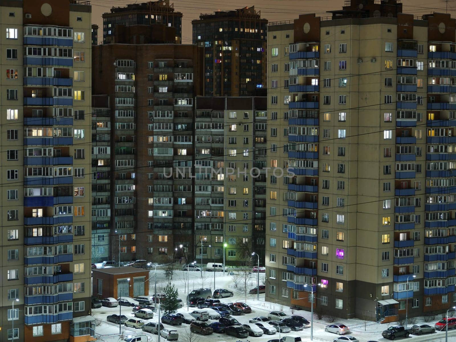 St. Petersburg, Night city in winter, residential buildings, parking light in the windows aerial view