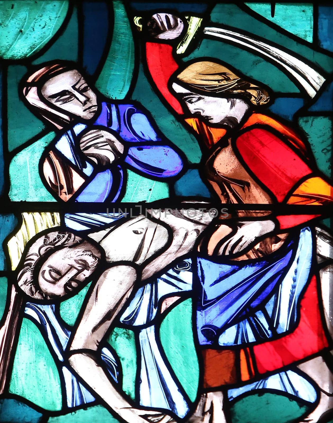 Judith, liberator of her people, kills the enemy captain Holofernes, Stained glass window in Basilica of St. Vitus in Ellwangen, Germany
