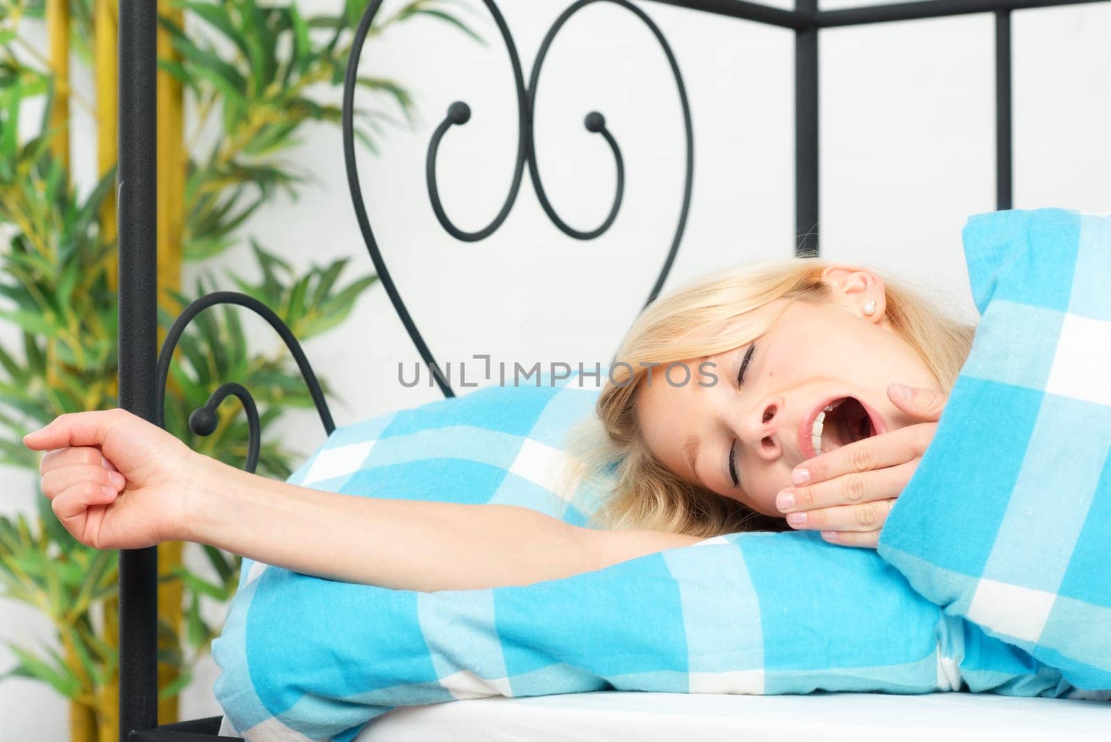 Woman in bed has woken up and yawned