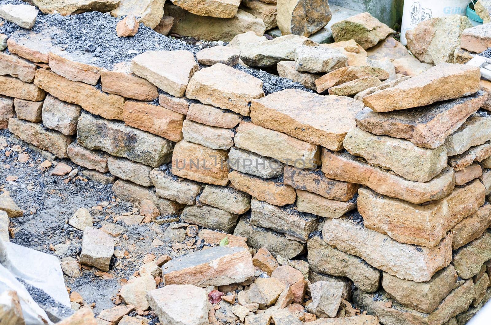 Stone wall made of sandstone in drywall construction process.