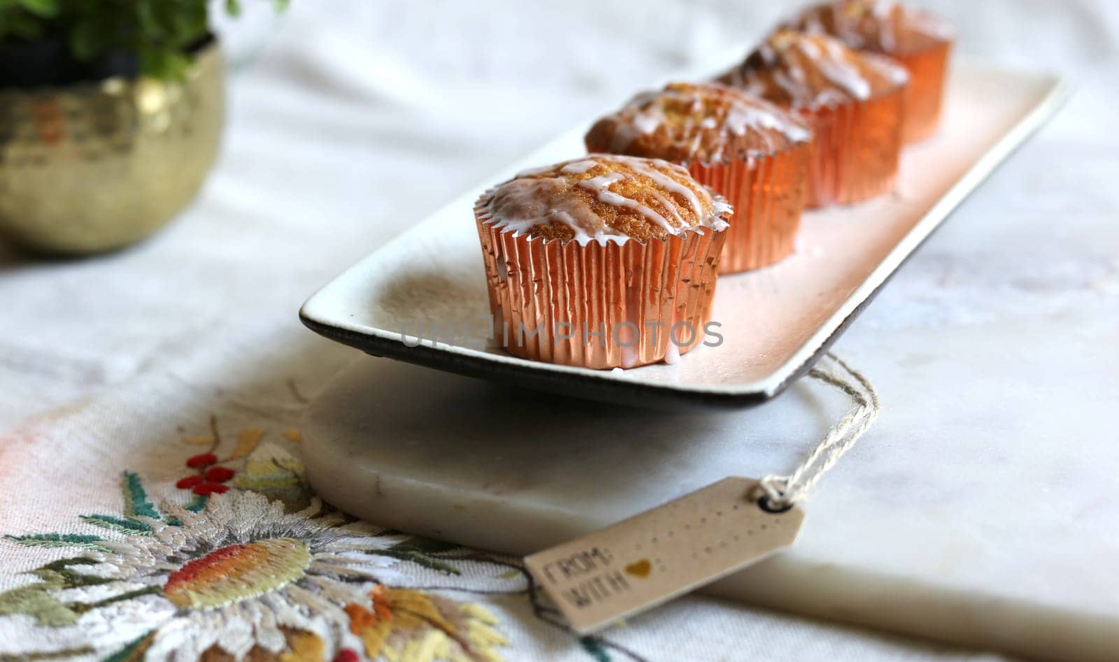 Sweet cakes on marble. Cup cakes on a kitchen table. Vintage sweets, vintage tablecloth with embroidery on linen fabric, gift tag for mock up