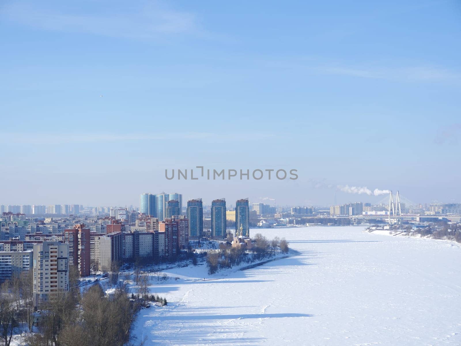 skyscrapers on the banks of the river white from snow, in the distance on the horizon a big city top view