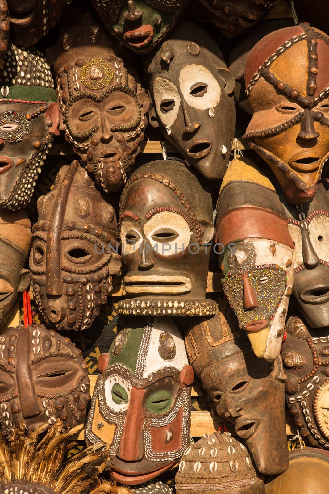 Traditional african masks hanging for sell in a market stall.