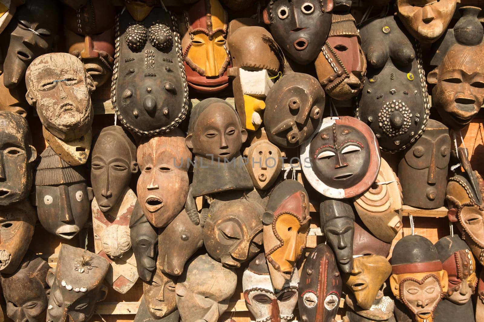 Traditional african masks hanging for sell in a market stall.