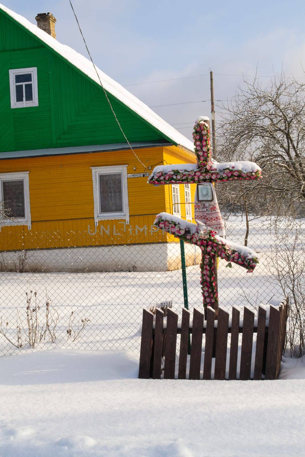 Old wooden cross standing at the crossroads in a village, Belarus.Old Christian orthodox tradition. Vertical image