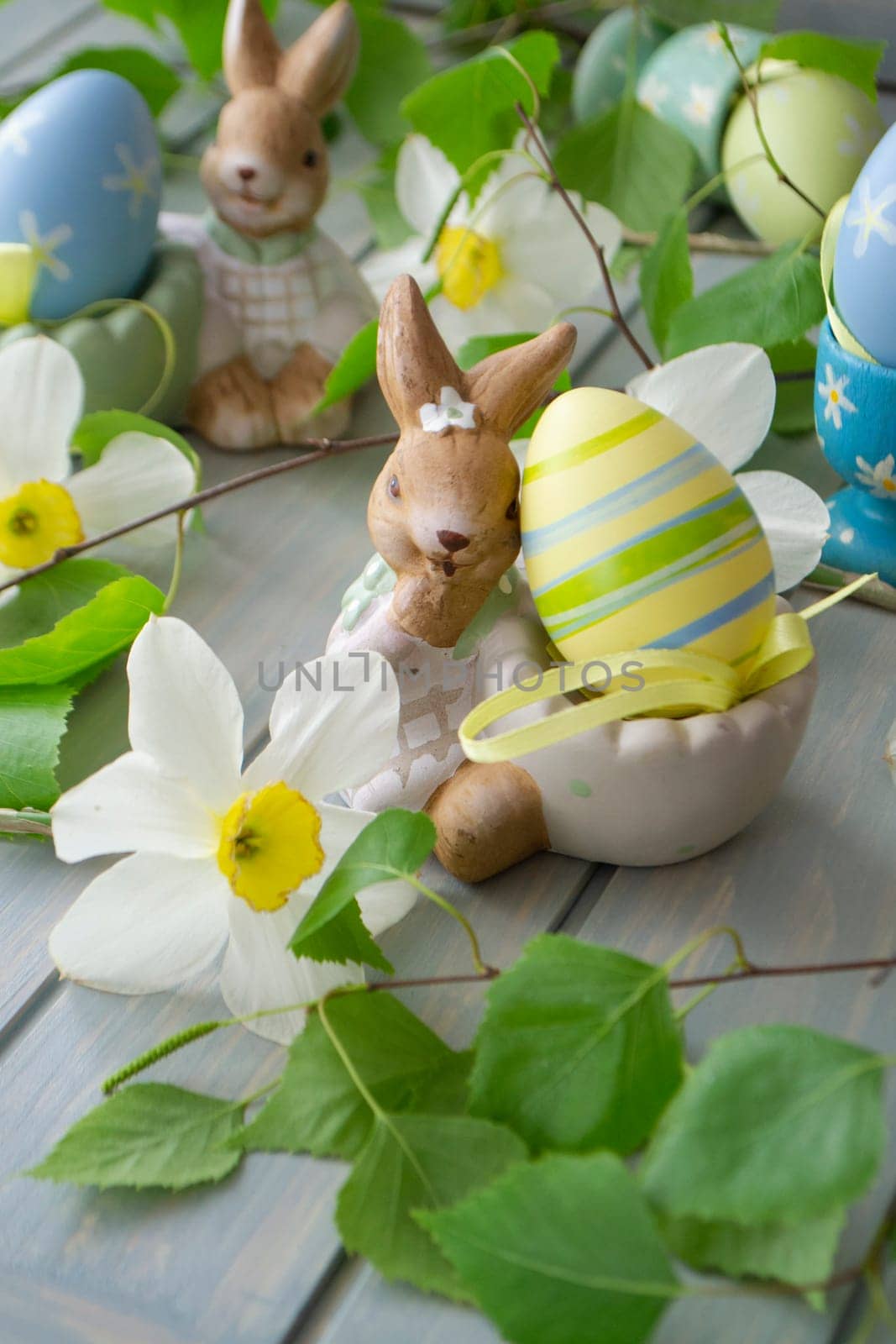 Easter decoration with rabbit, spring flowers and eggs. Vertical image