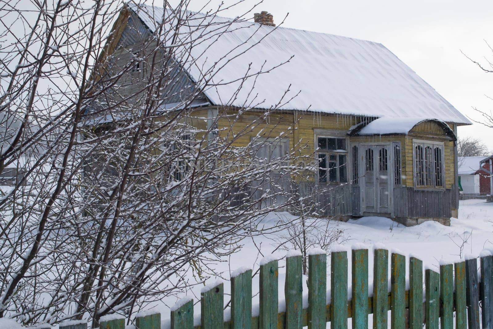 abandoned old house in belarussian village, winter grey day
