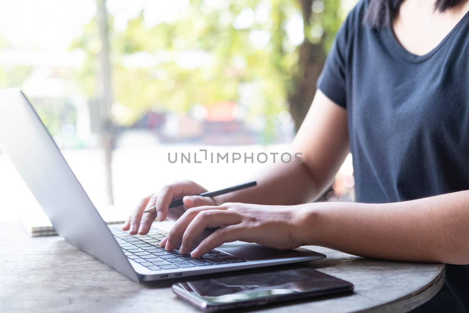 Close up female hands of a business freelance using laptop computer, searching in cafe. Working online technology system concept.