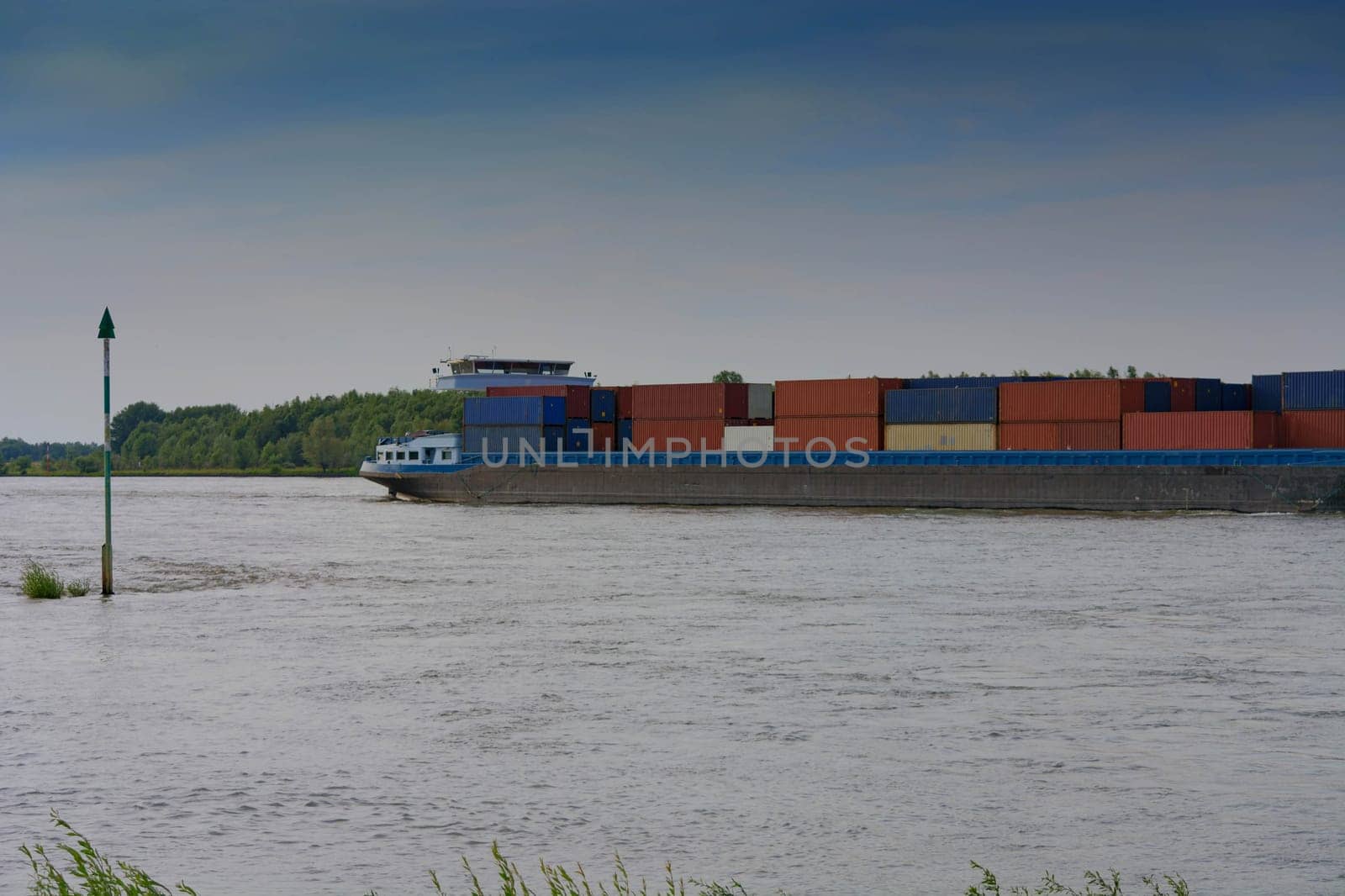 Logistics Import-Export. In the background of the container cargo ship the Rheinufer with blue sky, freight traffic