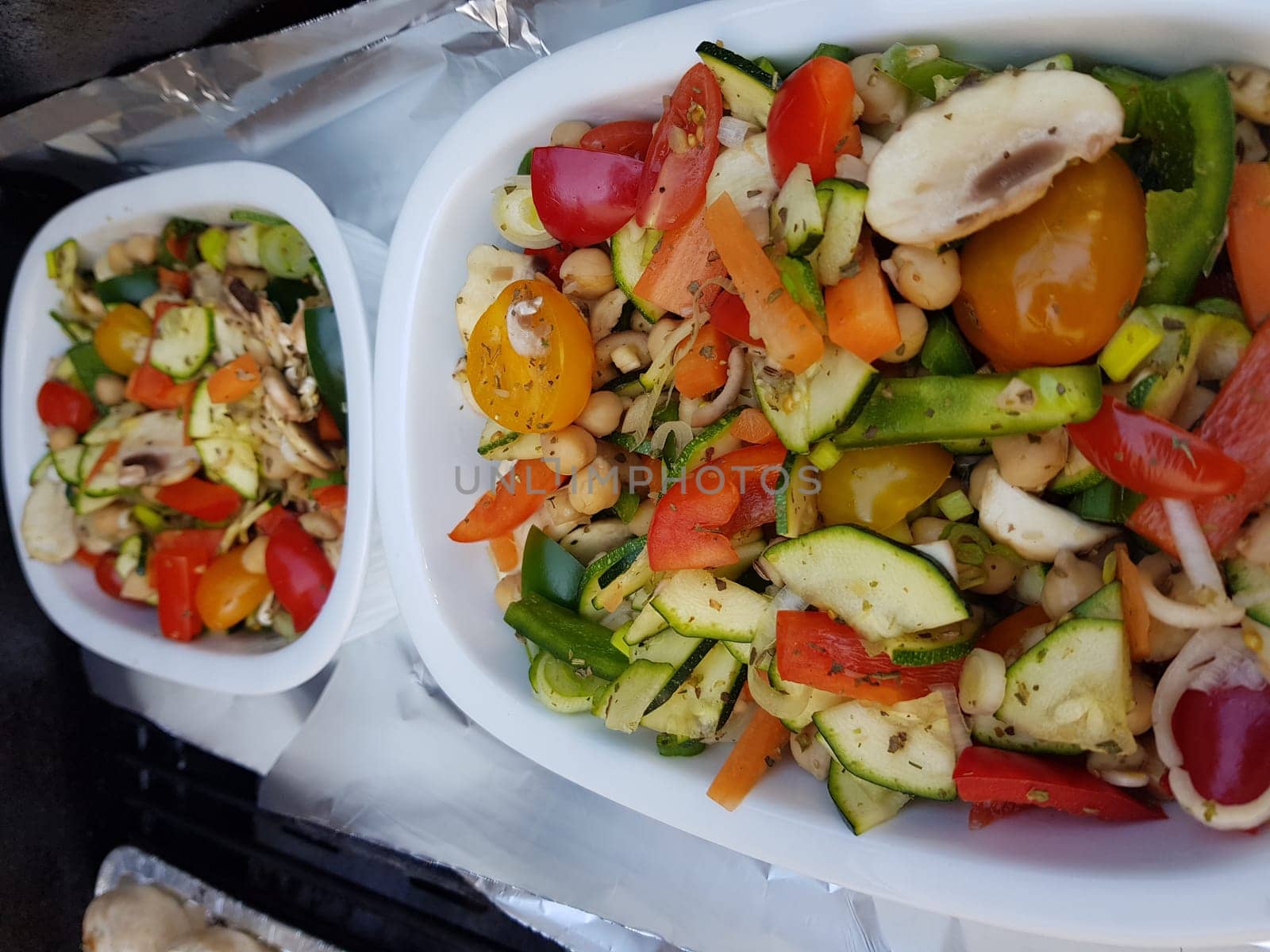 Grilled vegetables on a barbecue grill in a white bowl, top view