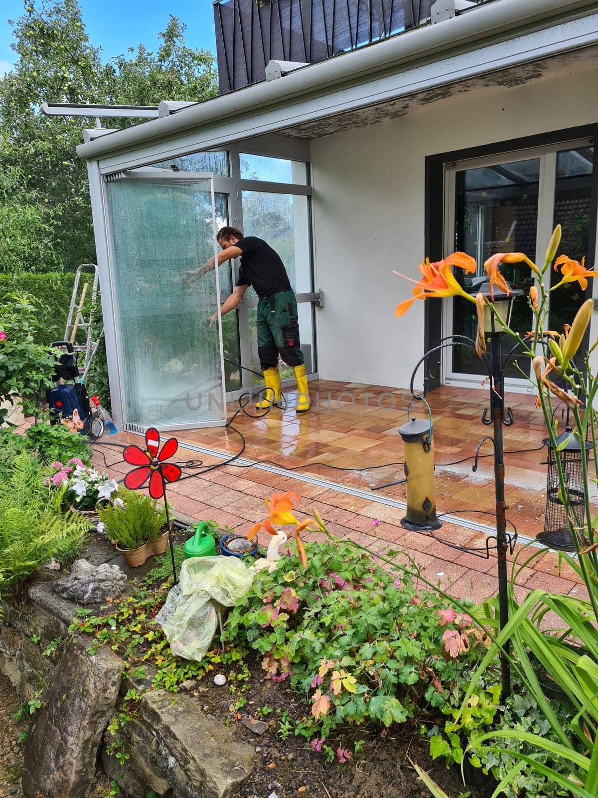 Man power washing conservatory roof and windows