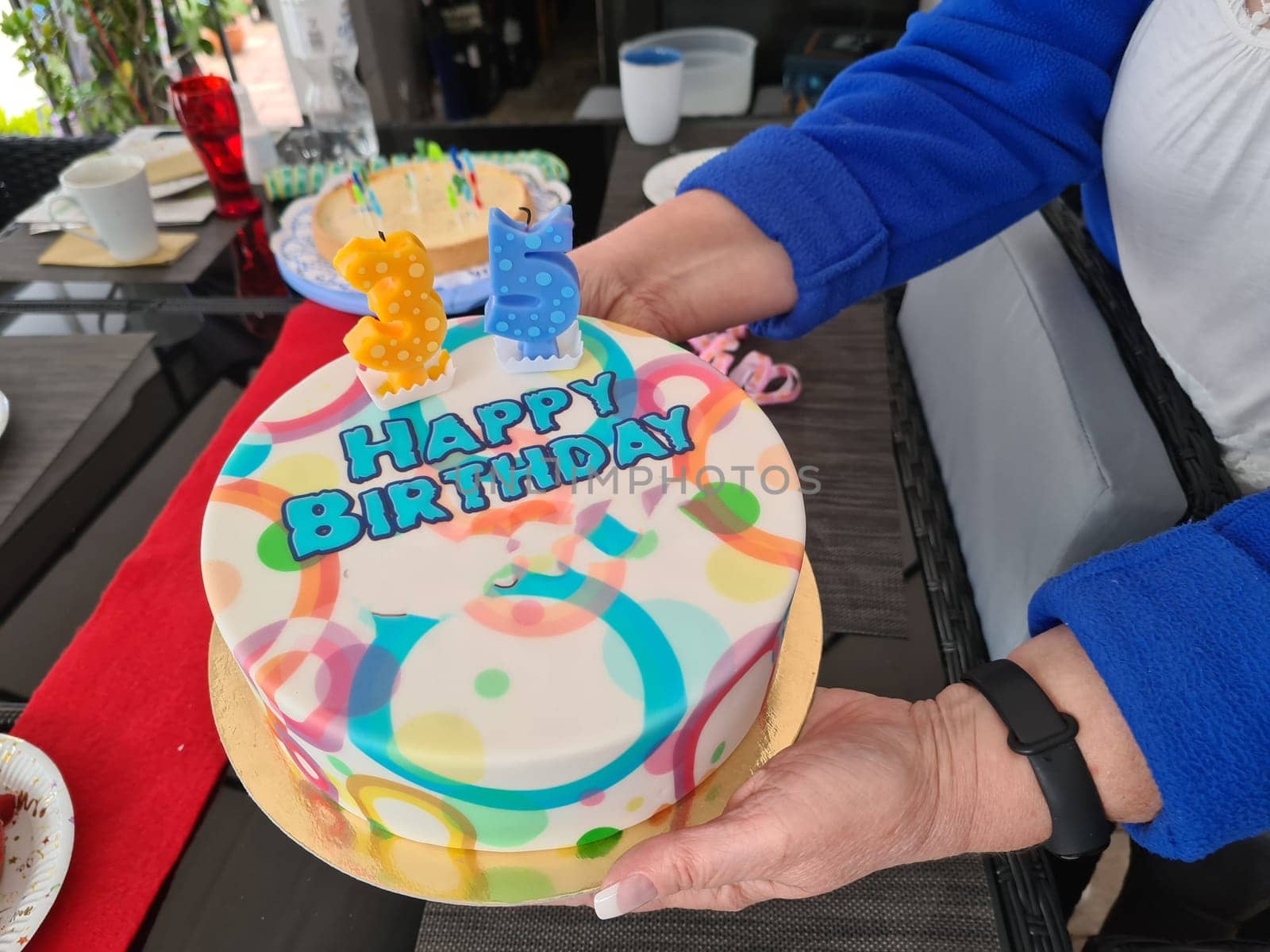 Delicious birthday cupcake in the hand with background.