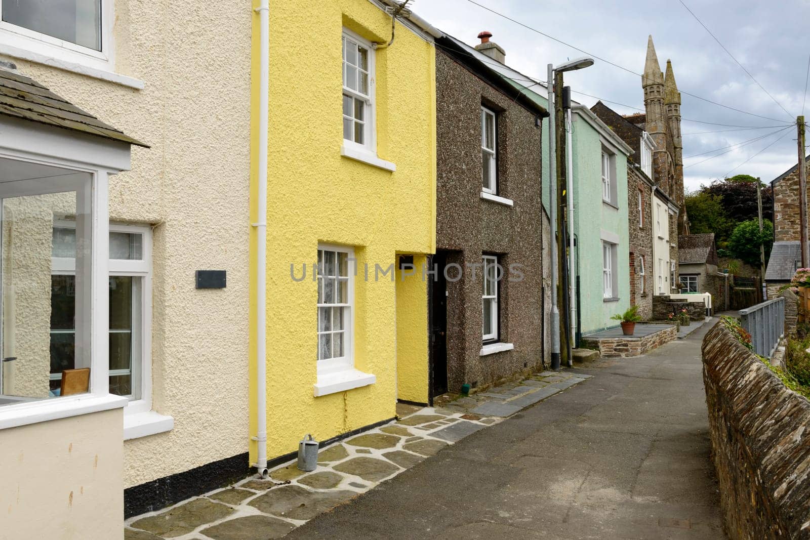view of street with old houses in the village on southern coast of Cornwall.
