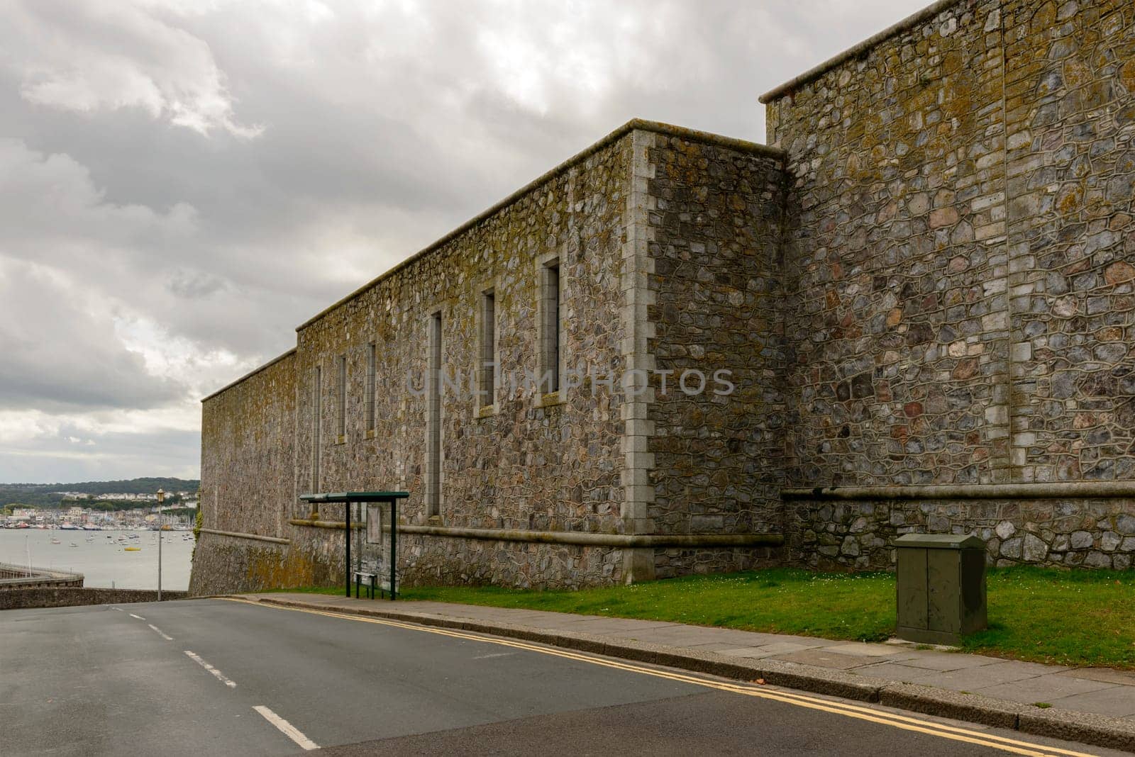 view of the huge wall that encloses the area of the castle in historic sea town of Devon.