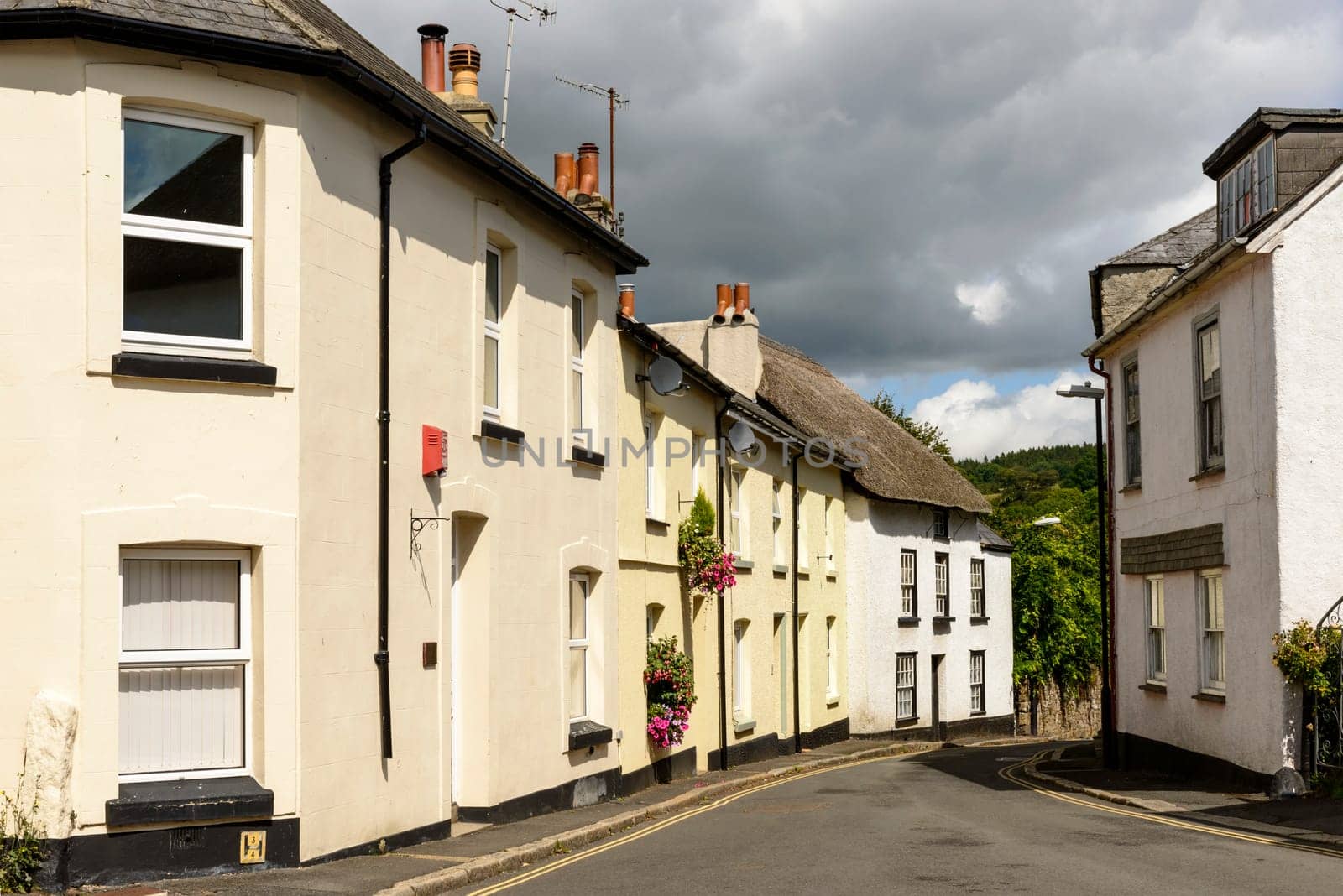 view of bending street with old houses in the touristic village in the Dartmoor region.