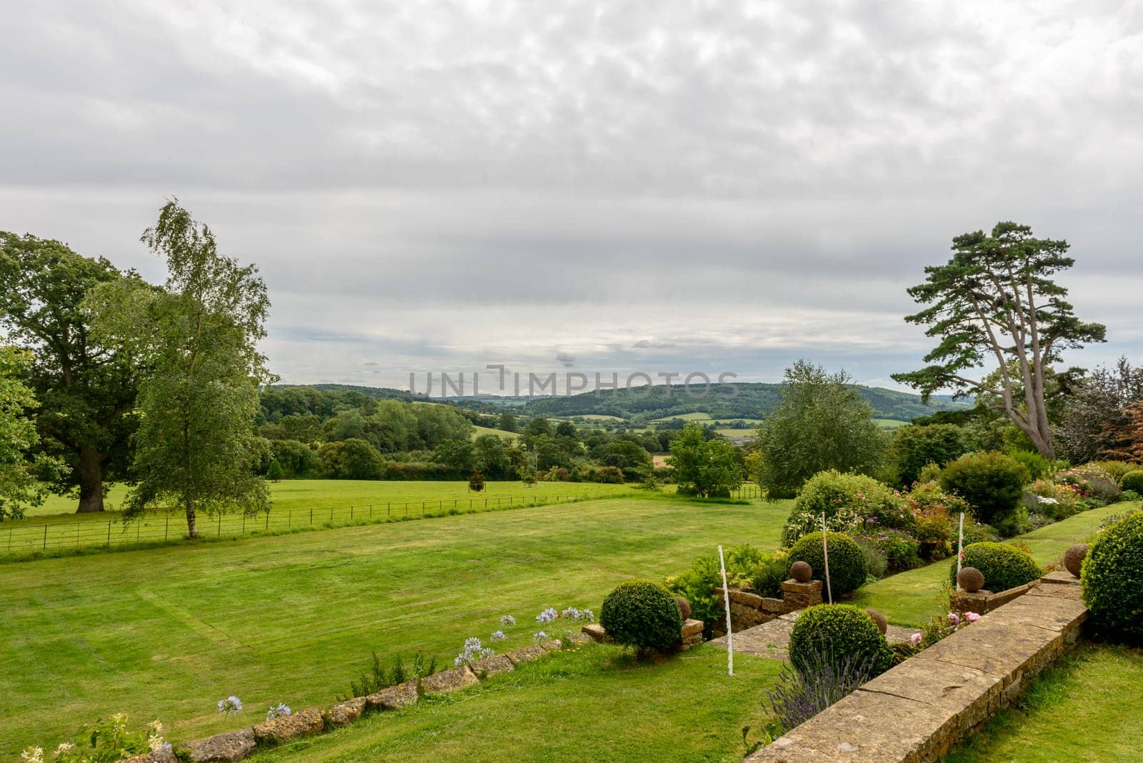view of a green garden amid the lush Devon countryside, shot under bright cloudy sky.