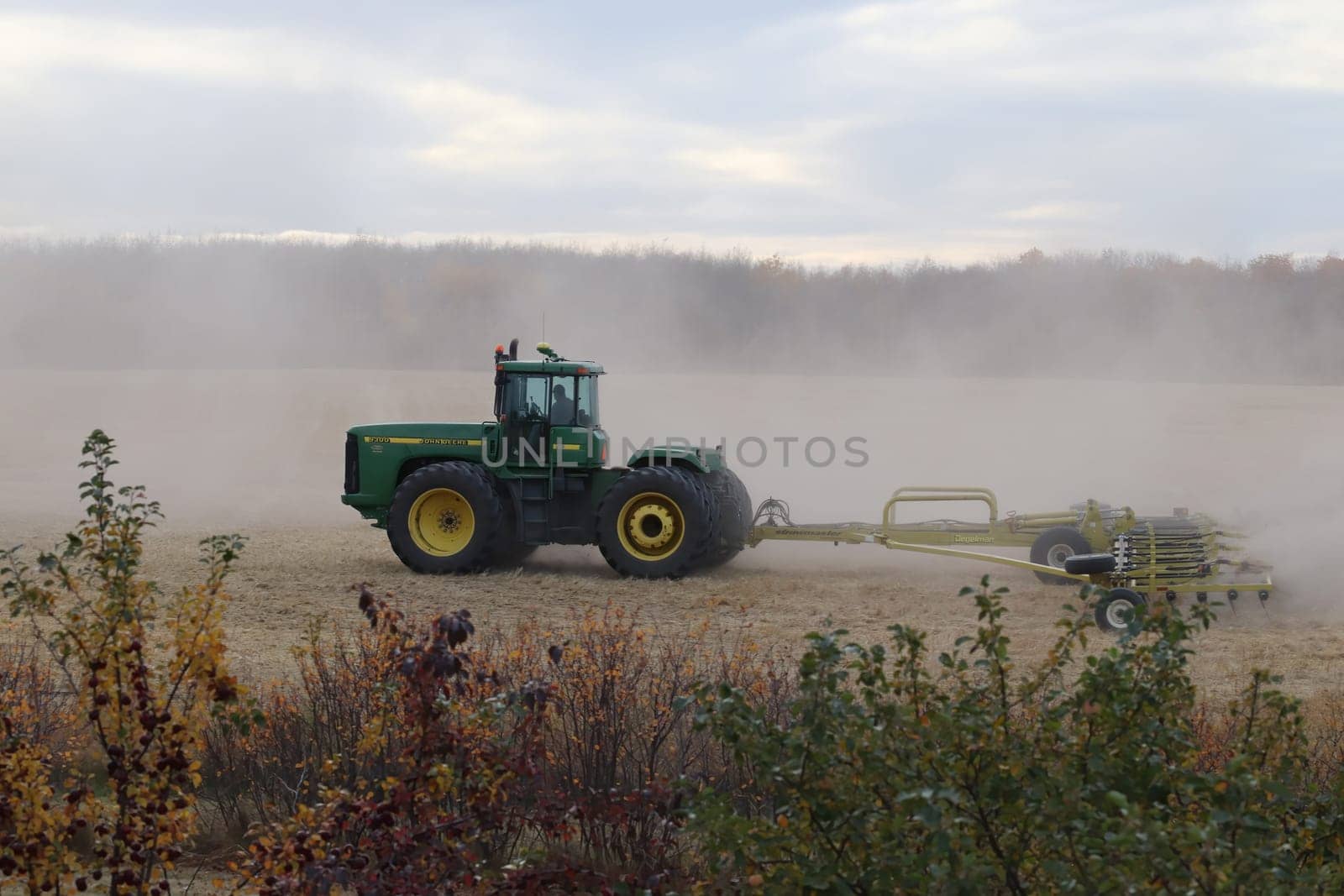 BONNYVILLE, ALBERTA, CANADA - SEPTEMBER 10, 2020: A local farmer in John Deere tractor works with a Degelman Stawmaster to harrow a field after harvest.