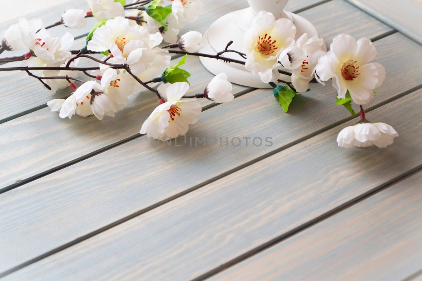 Spring morning concept. White flowers decoration over light blue background with copy space