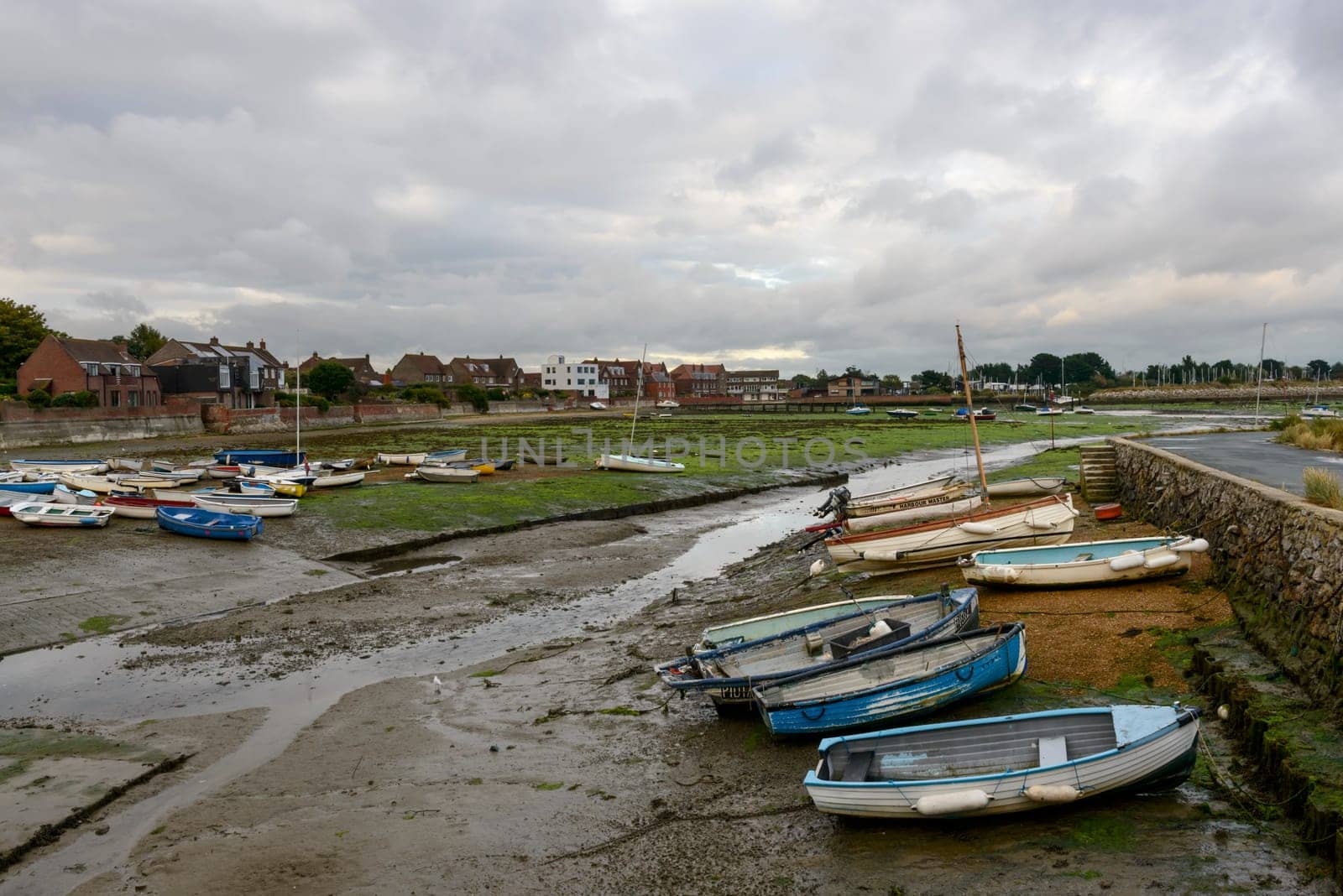 view of the touristic sea village  with boats aground at low tide time .