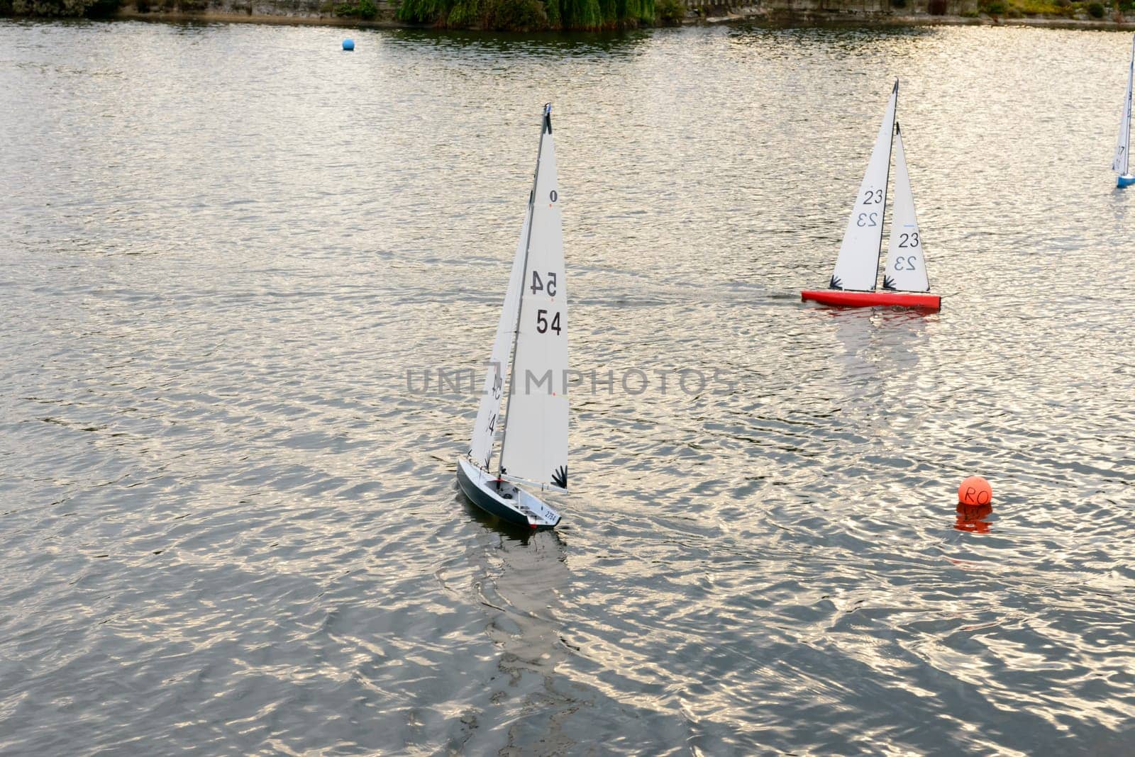miniature sail boats racing in sea pond at touristic sea village .