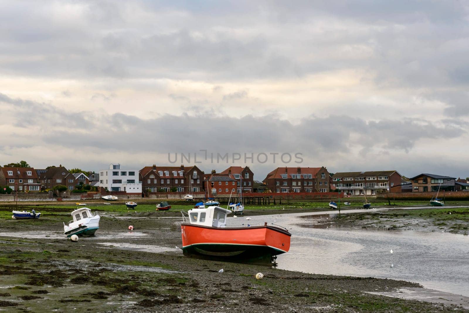 view of old boats aground at low tide time in the touristic sea village.